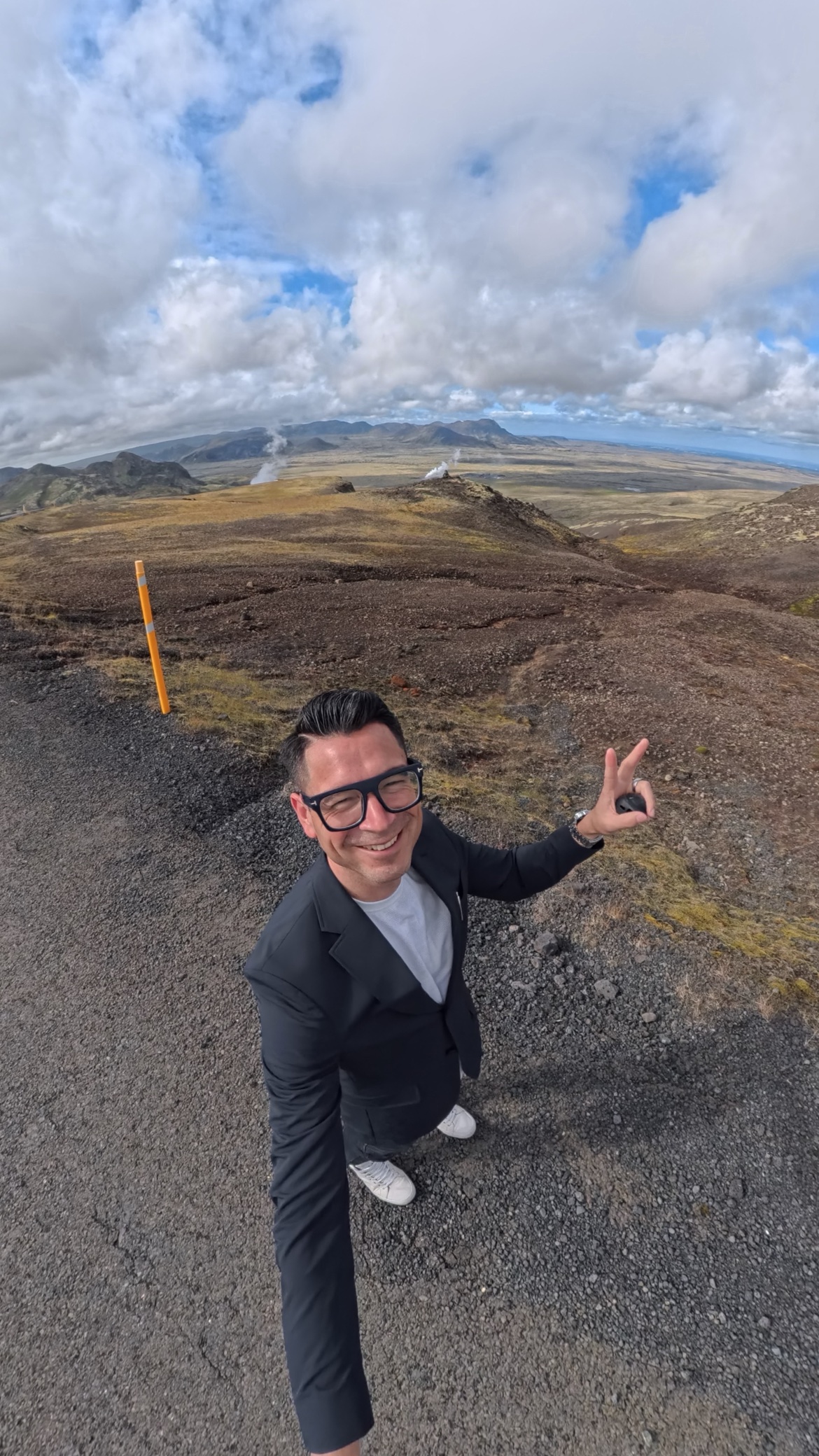 Javier taking a selfie in a geothermal field in Iceland with fumaroles behind him