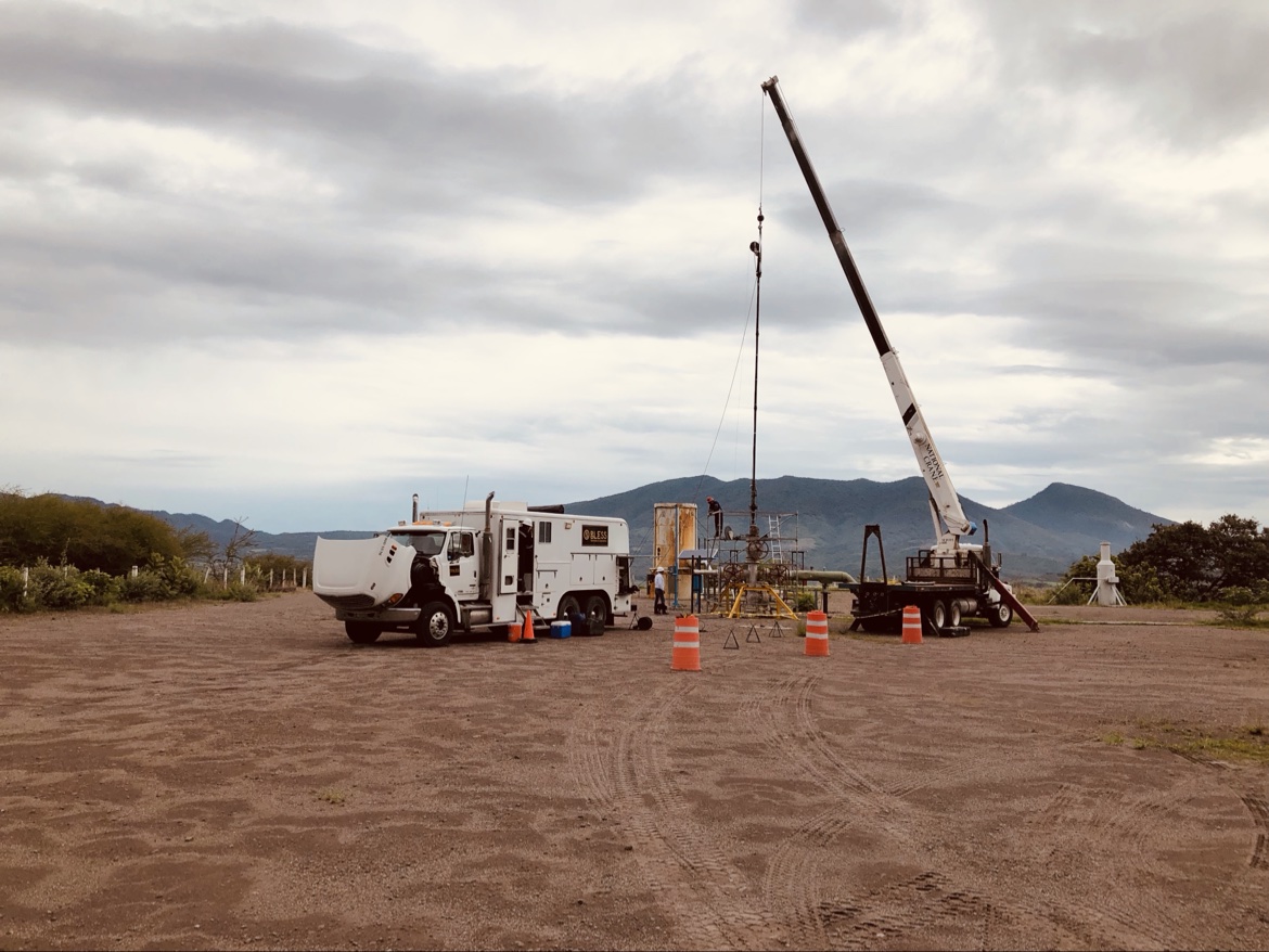 Wireline logging truck and crane next to a geothermal wellhead
